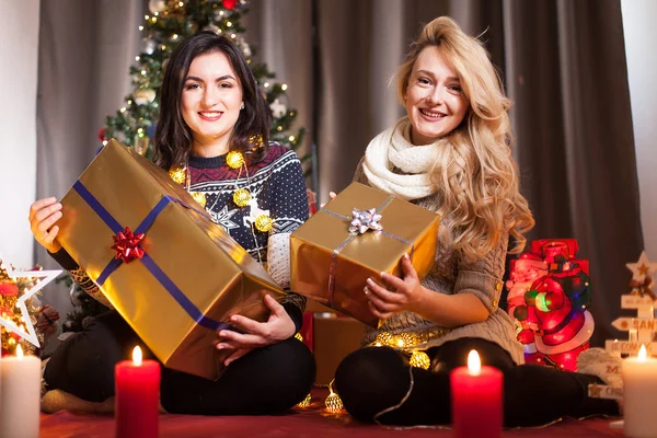 Sharing is caring. Happy girl friends exchange boxes with gifts