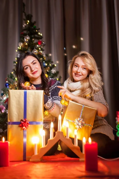 Heureux amis avec de grandes boîtes-cadeaux dans la chambre décorée de Noël — Photo