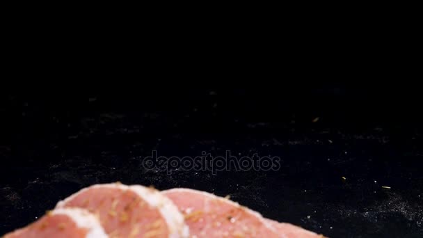 Câmera lenta zoom fora dolly tiro em quatro pedaços suculentos de bifes sendo temperado com pimenta — Vídeo de Stock