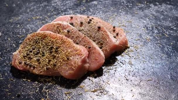 Slow motion over head crane shot on four healthy and delicious seasoned pieces of raw pork steak — Stock Video