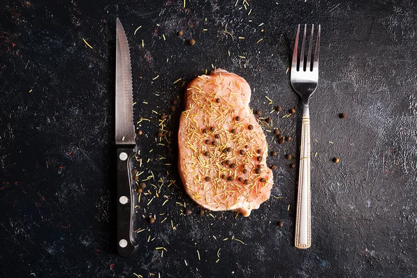 Yanında çatal ve bıçak siyah ahşap masa üzerinde çiğ biftek et