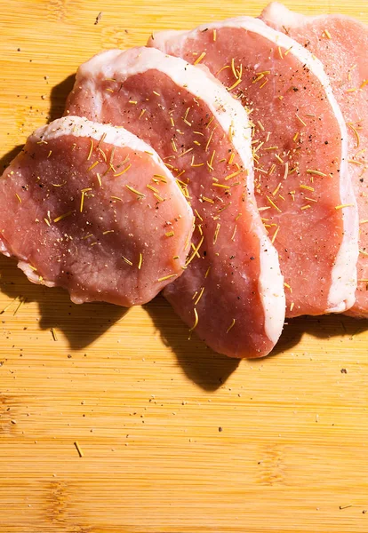 Primer plano sobre la carne cruda sazonada con especias, sal y pimienta —  Fotos de Stock