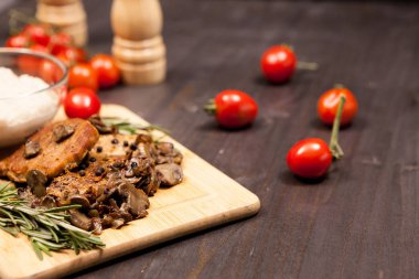 Izgara domuz biftek, mantar domates ve bir plaka ile b