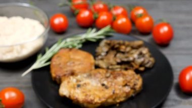 Domuz eti ızgara mantar, kekik, fasulye makarna ve domates yanında bir tabak içinde atış vinç