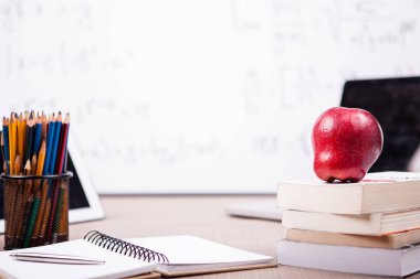 Kitap, defter ve kalemler bulanık bir beyaz tahta masada