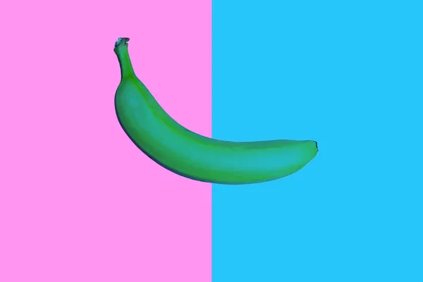 Pop art green colored banana on vivid two colored background — Stock Photo, Image