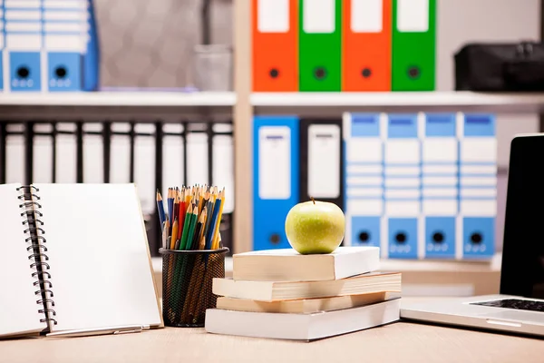 A könyvek mellett egy jegyzetfüzet és ceruza-t a rakás zöld alma — Stock Fotó