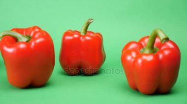 Beş tatlı kırmızı biber yeşil arka plan üzerinde izleme dolly odak kapatın