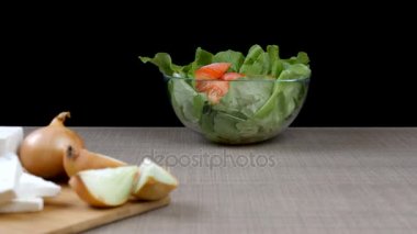 Dolly domates salatası yeşil salata ile izleme odak yapraklar, soğan ve beyaz peynir ahşap tahta üzerinde