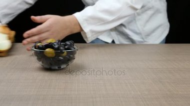 Şef olan iki soğan bir kesilir peynir, zeytin bir kase ve domates salatası kesilmiş parçaları yapılmış bir tablo düzenler