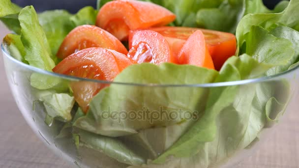 Tigela de folhas de salada com tomates fatiados — Vídeo de Stock