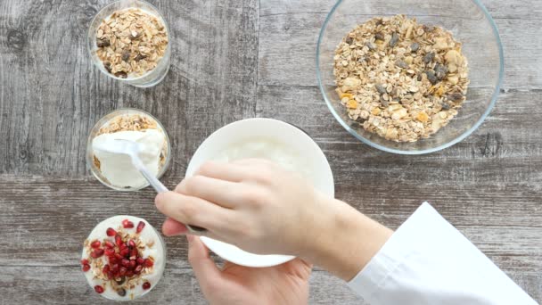 Pohled shora rukou šéfkuchař připravuje müsli s přírodní jogurt — Stock video