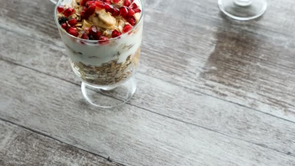 Vue de dessus dolly parallax shot sur délicieux muesli fait maison avec yaourt naturel et grenade — Video