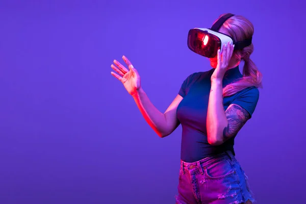 Mujer con auriculares de realidad virtual sobre fondo azul — Foto de Stock