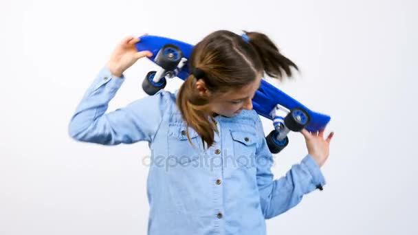 Menina adolescente feliz bonito com um skate em suas mãos — Vídeo de Stock