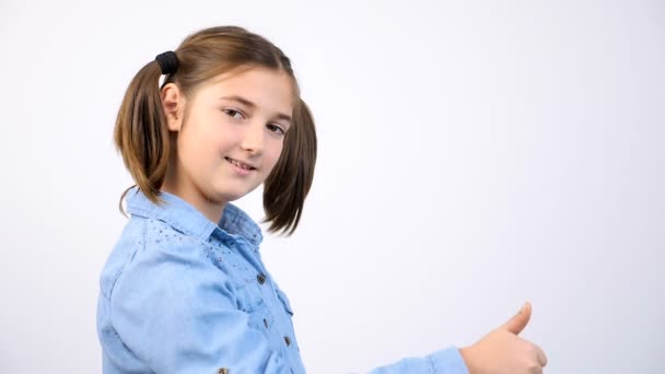 Ładna dziewczynka Wyświetlono kciuk w górę znak na szarym tle — Wideo stockowe