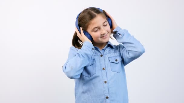 Little girl with headphones on listening to music — Stock Video