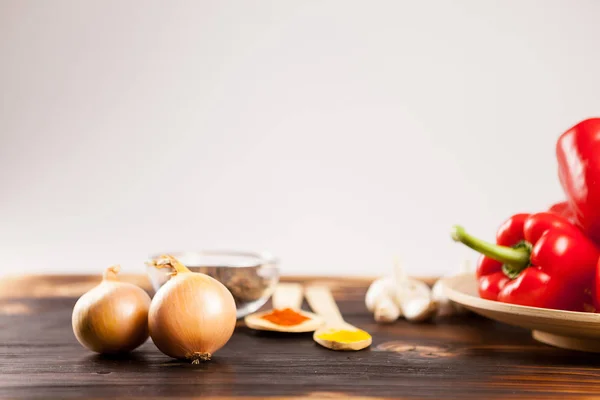 Cebollas con pimiento rojo dulce en un plato de madera —  Fotos de Stock