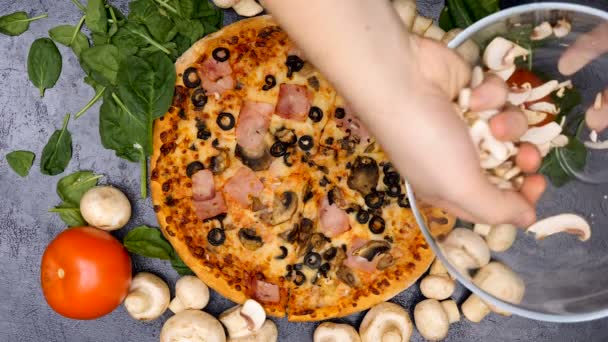 Top view of hands placing mushrooms on pizza — Stock Video