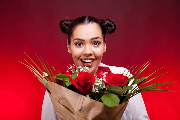 Femme tenant un bouquet de roses dans les mains souriant à la caméra — Photo