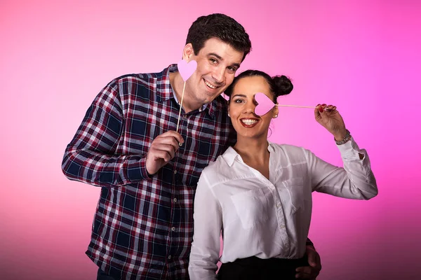 Счастливая влюбленная пара с розовыми сердцами в руках — стоковое фото