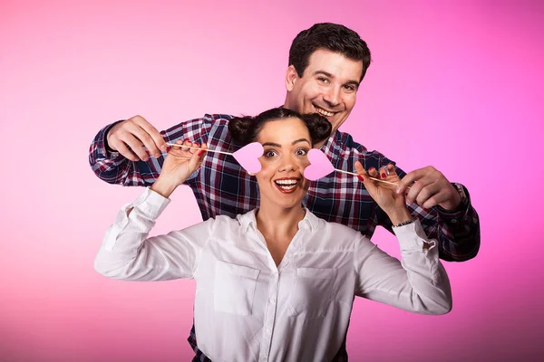 Casal em estúdio com dois corações cor-de-rosa beeing bobo — Fotografia de Stock