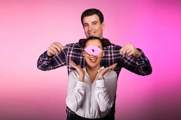 Casal em estúdio com dois corações cor-de-rosa beeing bobo — Fotografia de Stock