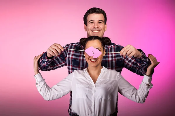 Casal em estúdio com dois corações cor-de-rosa beeing bobo — Fotografia de Stock