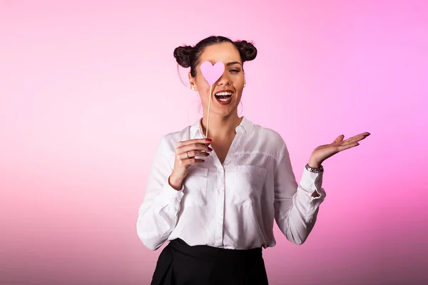 Kvinna som täcker ena ögat med en rosa hjärta — Stockfoto