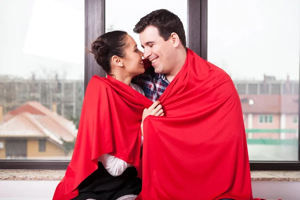 Paar bedekt met rode deken zitten samen — Stockfoto