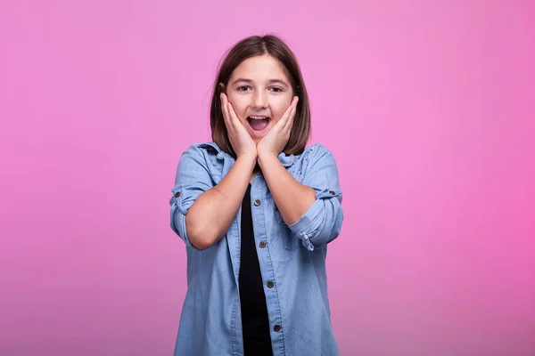 Suprised meisje op roze achtergrond in de studio — Stockfoto