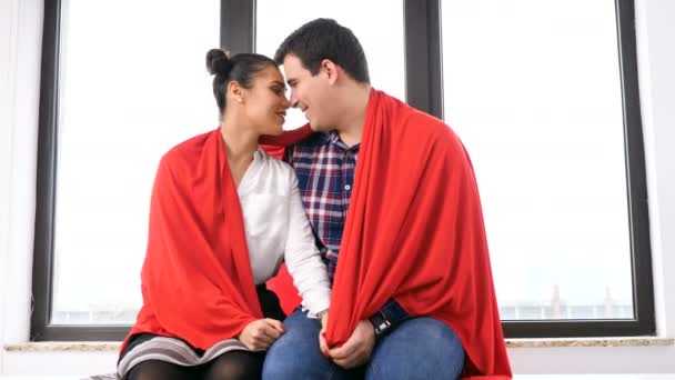 Romantische Paar mit einer Decke neben einem großen Fenster bedeckt — Stockvideo