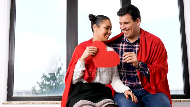 Movimiento lento de pareja jugando con un corazón de papper rojo — Vídeos de Stock