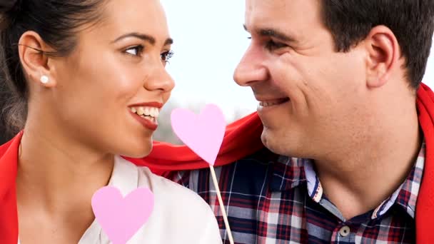 Belo casal brincando com corações de papper rosa — Vídeo de Stock