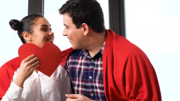 Pareja jugando con un corazón de papper rojo — Vídeos de Stock