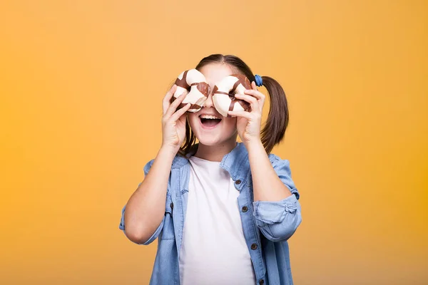 Nettes Teenager-Mädchen spielt mit zwei Donuts im Studio — Stockfoto