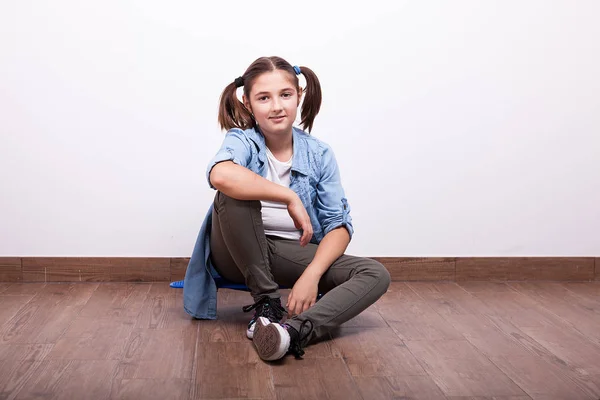 Lindo adolescente sentado en un monopatín —  Fotos de Stock