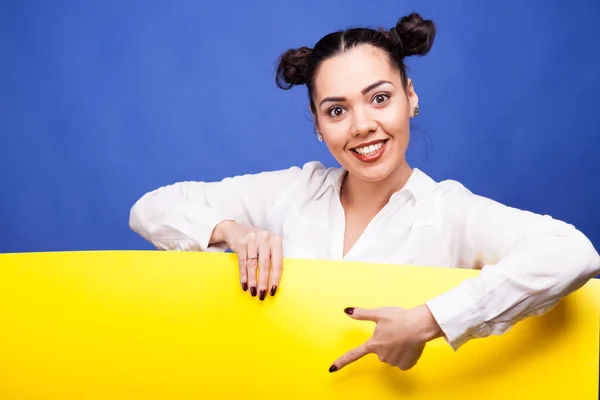 Vrouw die met haar vinger aan een gele spandoek — Stockfoto