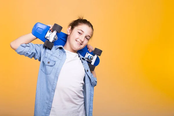 Feliz adolescente con su monopatín azul en los hombros —  Fotos de Stock