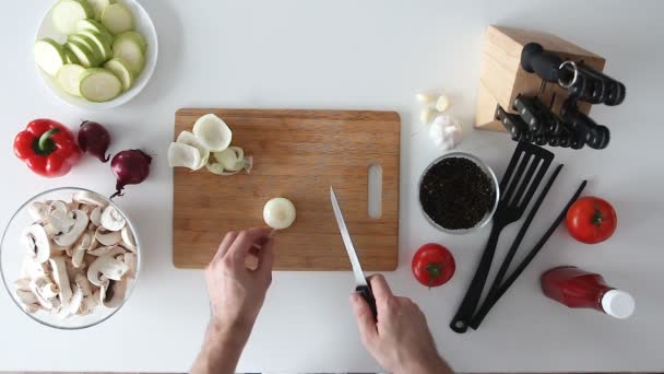 Cook cuts onion on wooden board — Stock Video