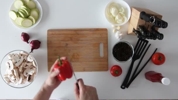 Snijden van een zoete rode peper op een houten bord — Stockvideo