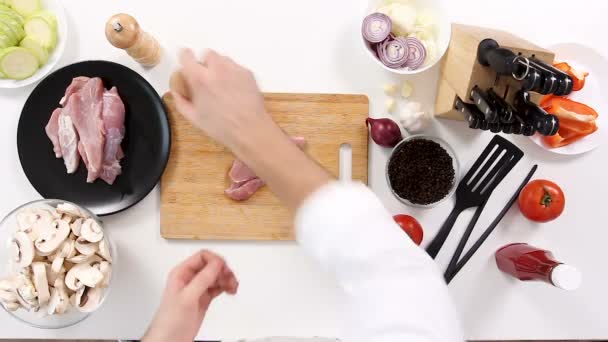 Koch salzt ein Stück rohes Schweinefleisch — Stockvideo