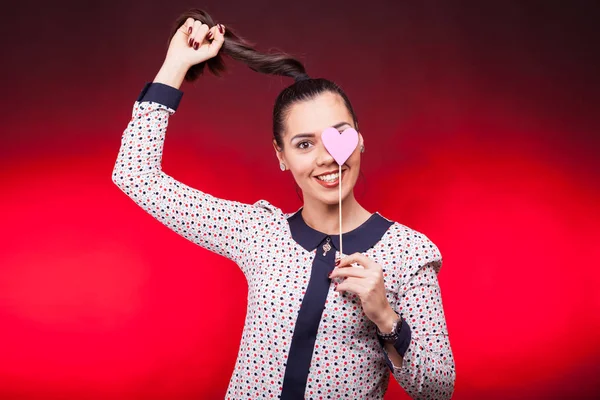 Portrait de femme heureuse avec un cœur de pappeur rouge à la main — Photo