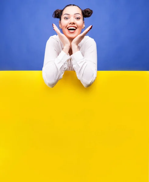 Lyckligt leende kvinna över en gul affisch styrelse — Stockfoto