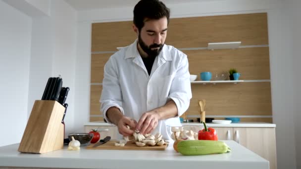 Koch in der modernen Küche legt geschnittene Pilze in eine Schüssel — Stockvideo