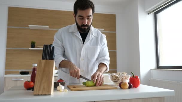 Koch in der modernen Küche schneidet einen Kürbis auf Holztisch — Stockvideo