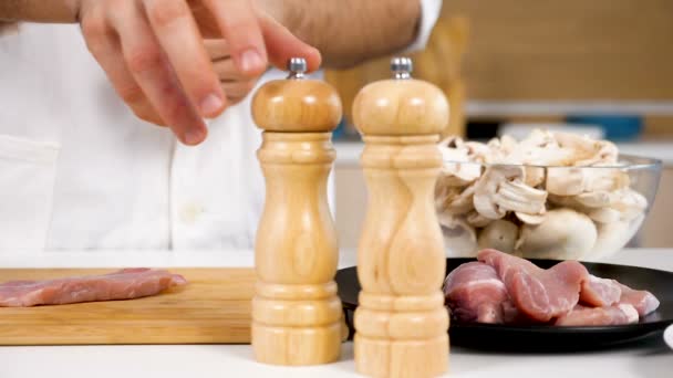 Seasoning and salting a piece of raw pork meat on wooden board — Stock Video