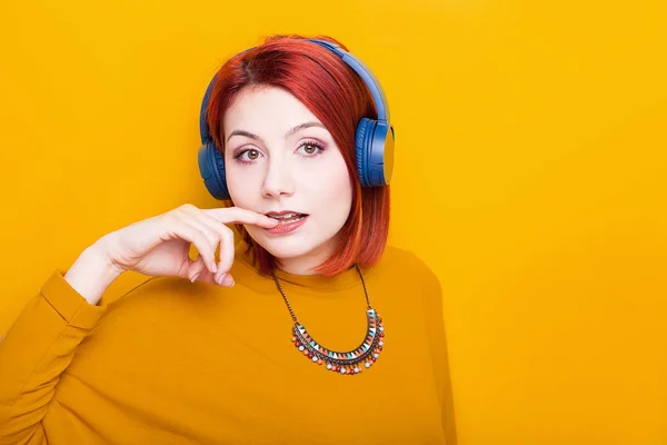 Mulher ruiva sexy usando fones de ouvido azuis — Fotografia de Stock