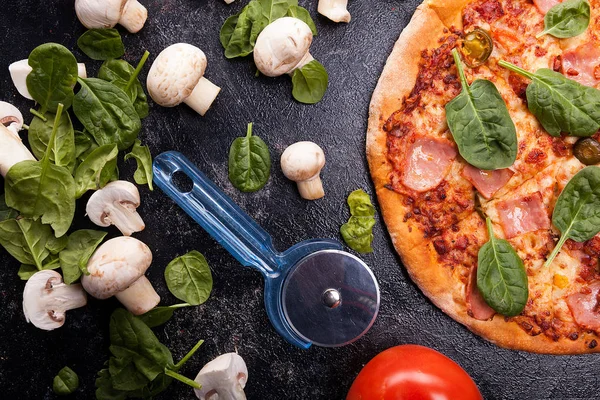 Top close-up op pizza naast paddestoelen, baby spinazie en t — Stockfoto