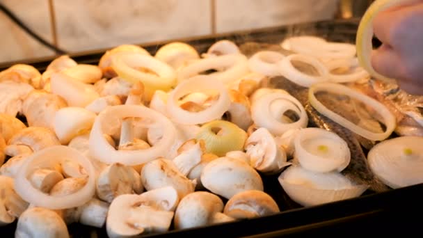 Zwiebelringe auf einem Grill mit Fisch und Pilzen hinzufügen — Stockvideo